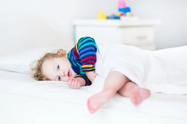 Adorable niña pequeña despertando por la mañana en un blanco soleado —  Fotos de Stock