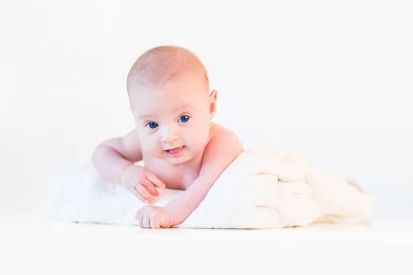 Niedliches Neugeborenes entspannt sich auf seinem Bauch auf einer weißen weichen Decke — Stockfoto