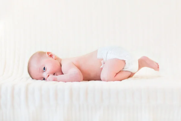 Schattige pasgeboren babyjongen ontspannen op een witte knitetd deken — Stockfoto