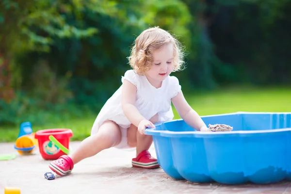 Liten flicka spelar med sand — Stockfoto