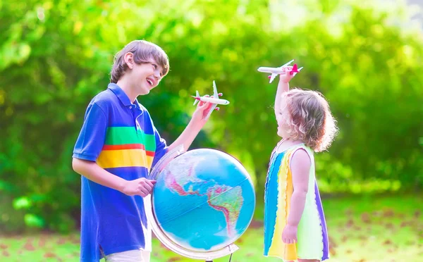 Crianças brincando com aviões e globo — Fotografia de Stock