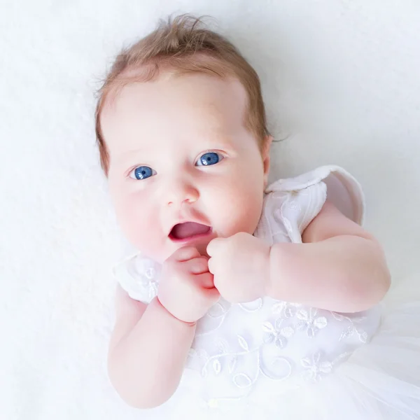 Bébé fille aux yeux bleus en robe blanche — Photo