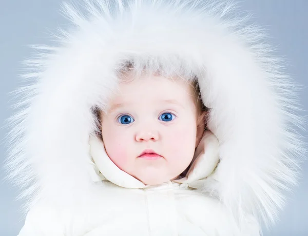 Close up retrato de um lindo bebê em uma jaqueta de inverno branco — Fotografia de Stock