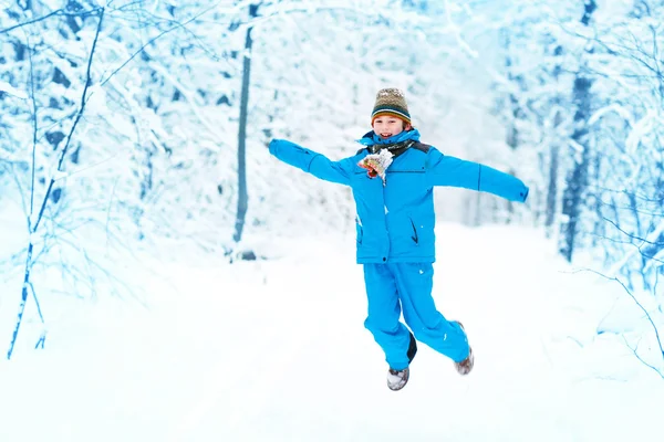 Funny boy hoppa i en snöig park — Stockfoto