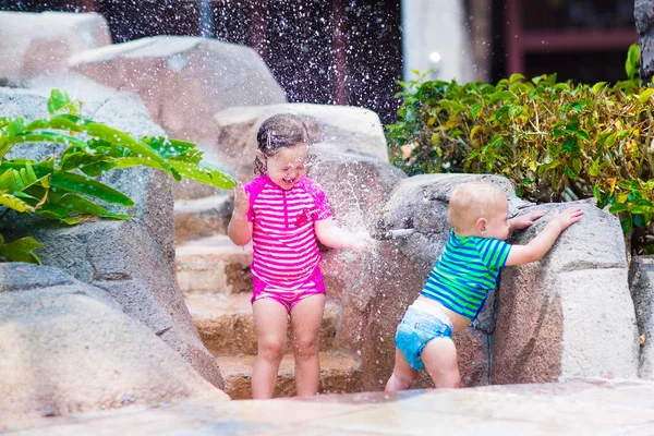 兄と妹の屋外水道で遊ぶ — ストック写真