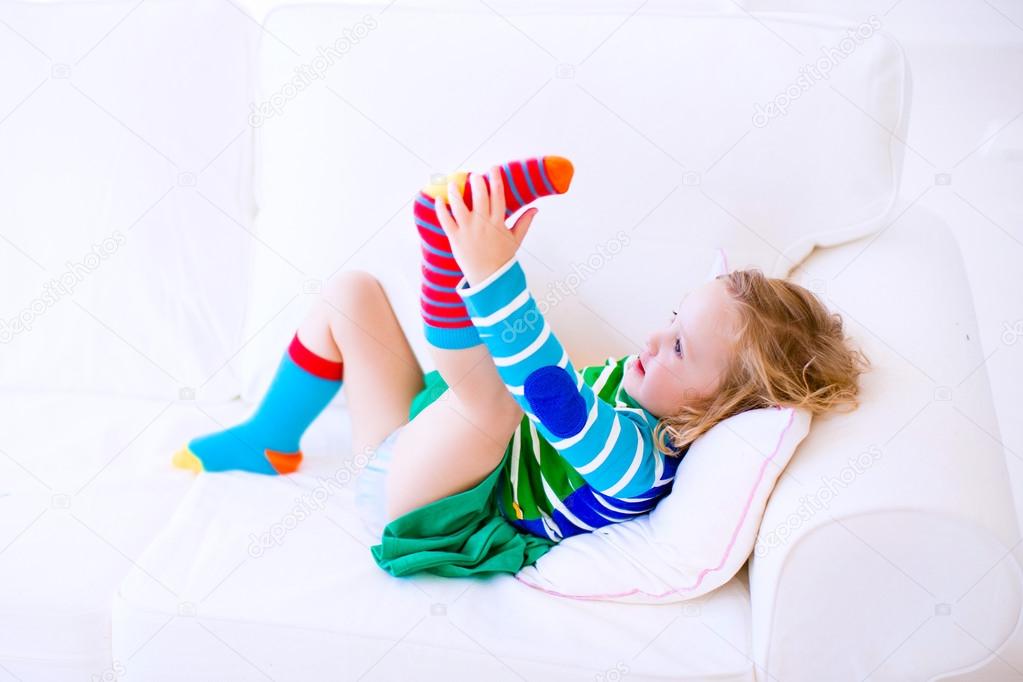 Little girl putting on socks