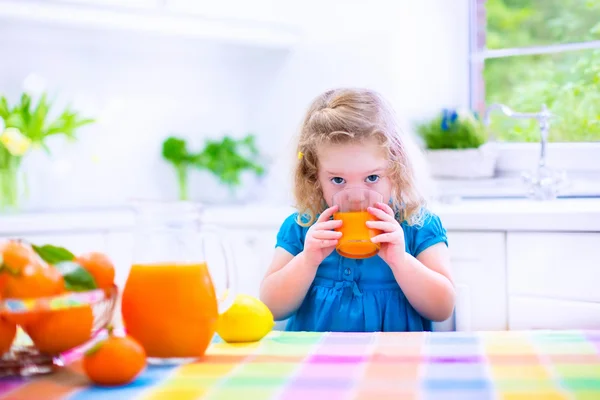 Menina bebendo suco de laranja — Fotografia de Stock