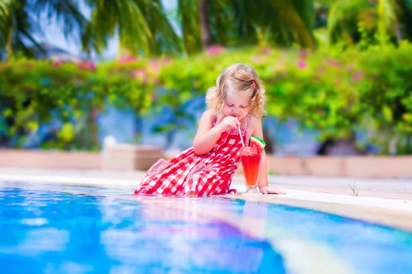 Little girl drinking juice at a swimming pool — Stock Photo, Image