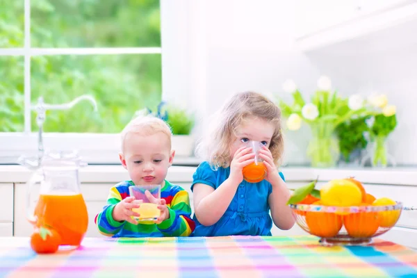 Crianças bebendo suco de laranja — Fotografia de Stock