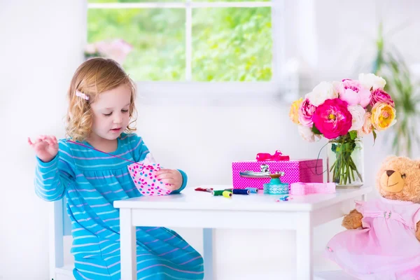 Little girl sewing a dress for her doll — Stock Photo, Image