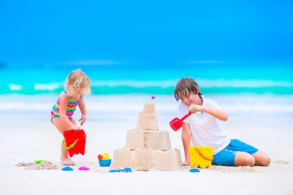 Bambini costruzione castello di sabbia sulla spiaggia — Foto Stock