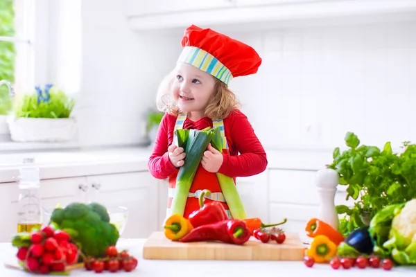 Маленькая девочка делает салат на ужин — стоковое фото