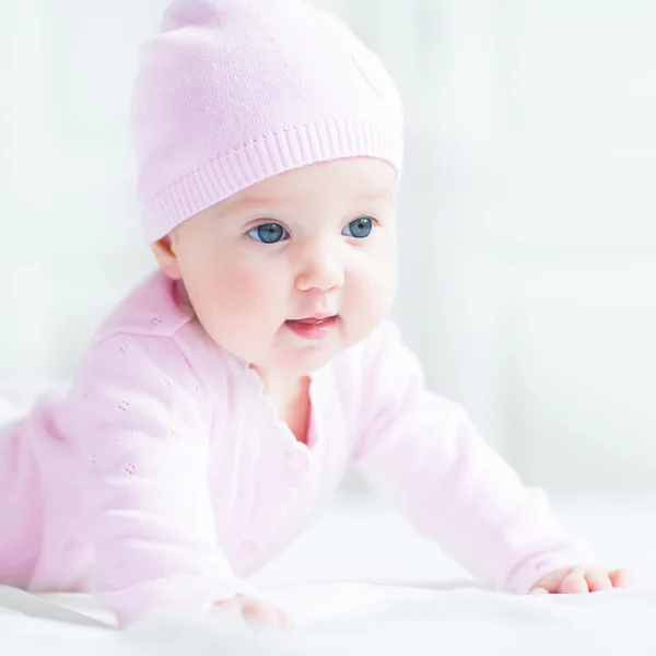 Feliz sorrindo bebê menina em um chapéu de malha rosa — Fotografia de Stock