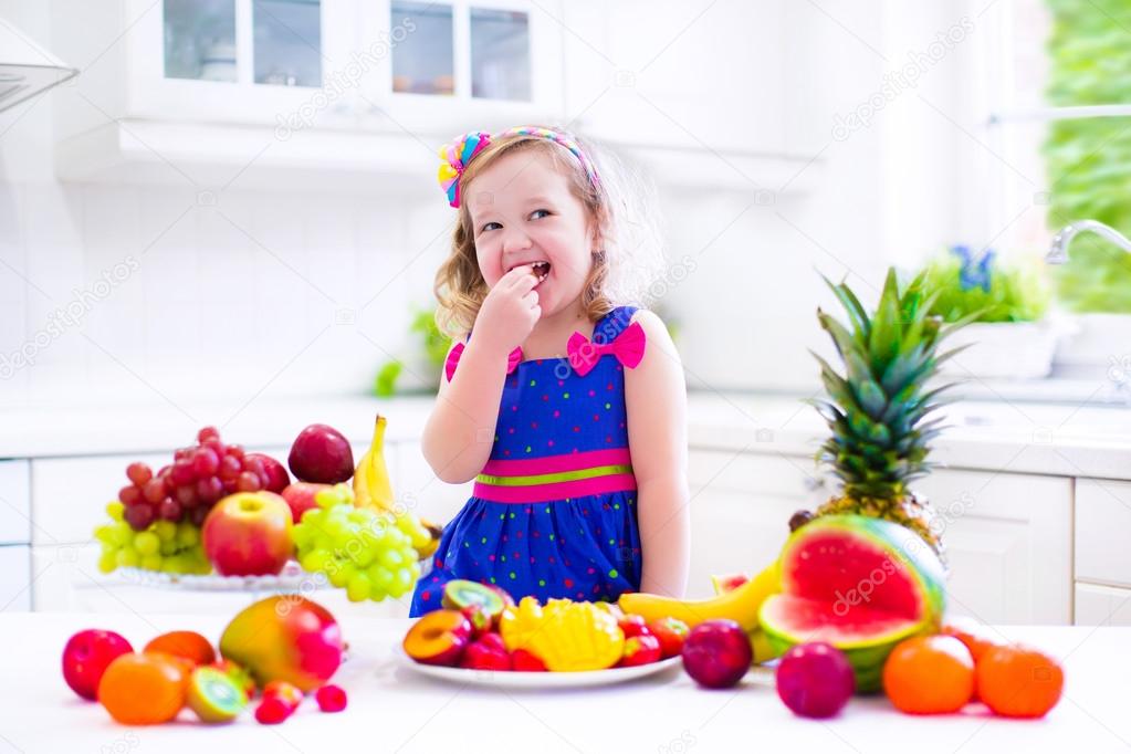 Little girl eating fruit