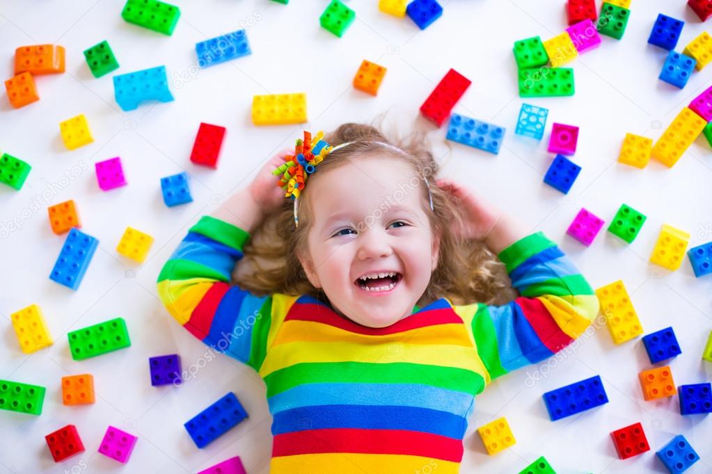 Little girl playing with toy blocks