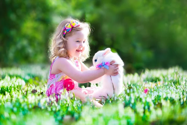 Kleines Mädchen spielt mit einem Kaninchen — Stockfoto