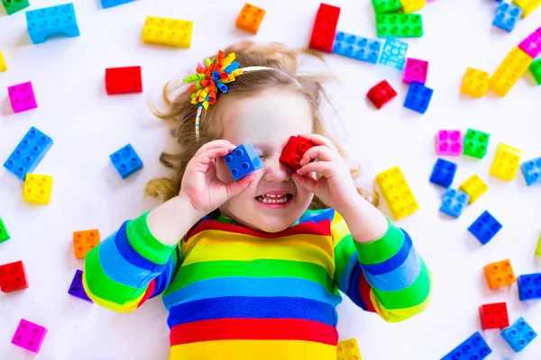 Маленька дівчинка грає з іграшковими блоками — стокове фото