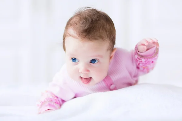 Linda niña divertida en un cárdigan rosa tratando de gatear — Foto de Stock