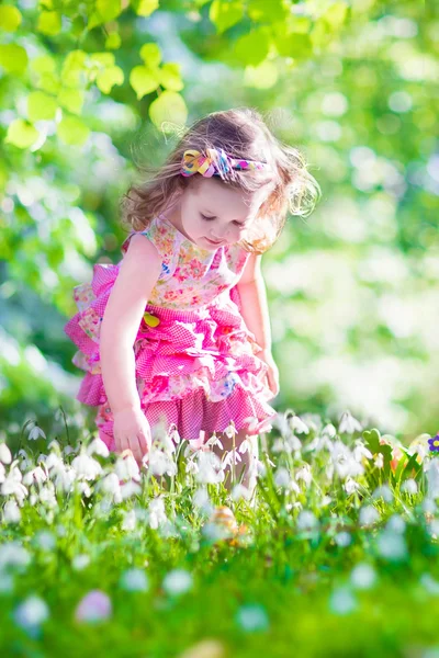 Liten flicka i blommande trädgård — Stockfoto