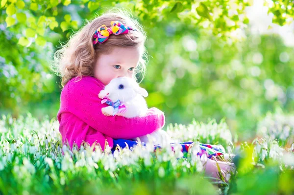 Маленька дівчинка грає з кроликом — стокове фото