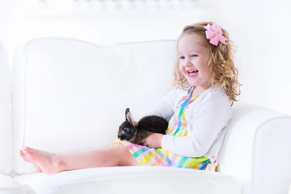 Küçük kız bir tavşan ile oynamak — Stok fotoğraf