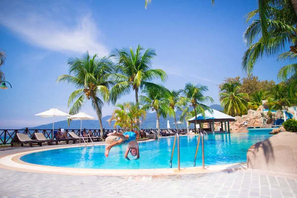 Boy jumping into a swimming pool — Stock Photo, Image