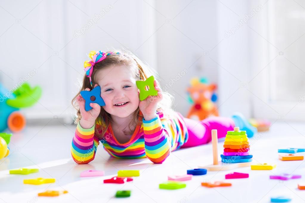 Little girl playing with wooden toys