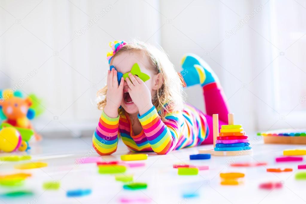 Little girl playing with wooden toys