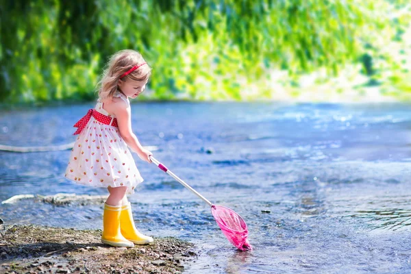 Little girl playing in a river — Stock Photo, Image