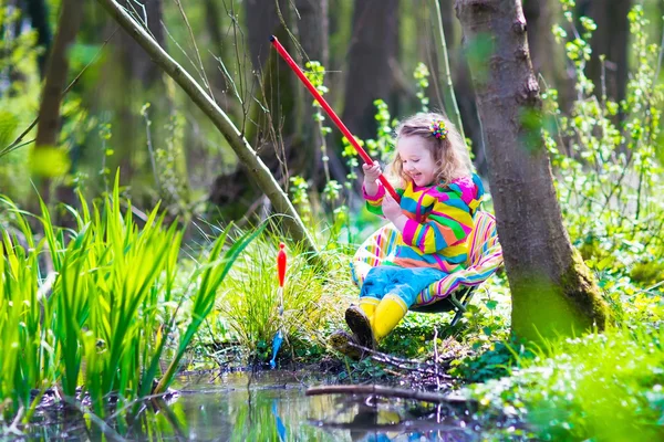 Little girl playing outdoors fishing — Stock Photo, Image