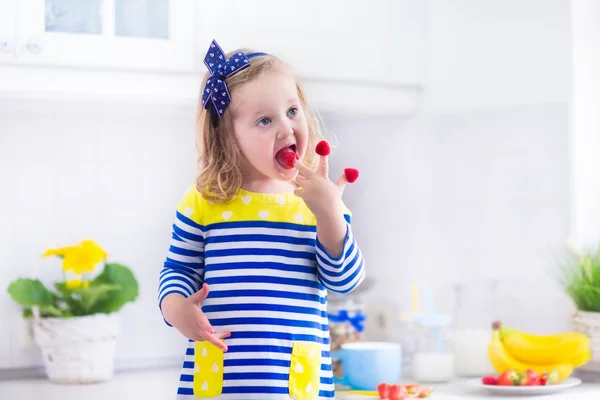 Lilla flickan förbereder frukost i ett vitt kök — Stockfoto