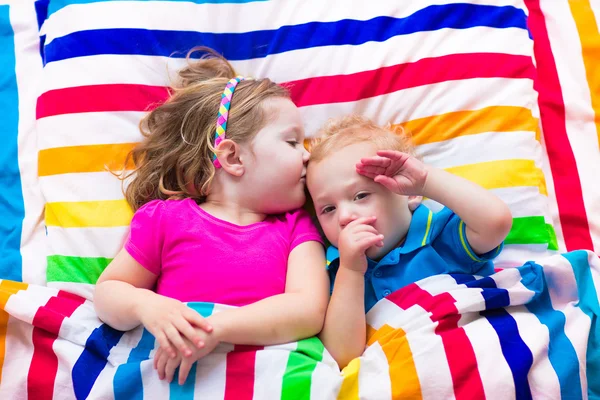 Niños durmiendo bajo una manta colorida —  Fotos de Stock