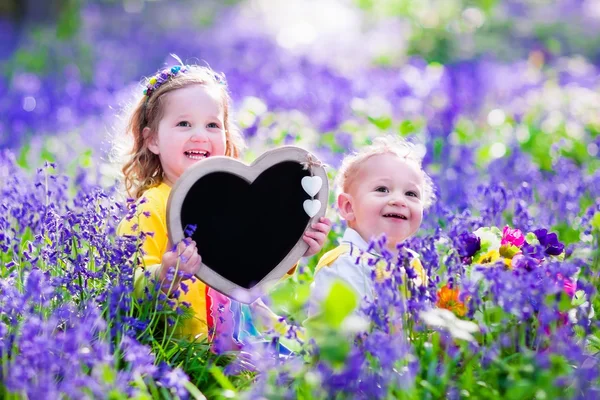 Crianças com flores e placa de giz — Fotografia de Stock