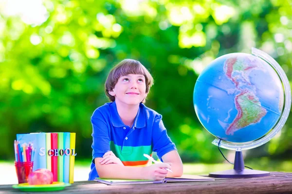 Ragazzo della scuola che fa i compiti nel cortile della scuola — Foto Stock