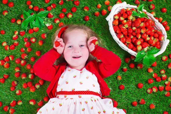 Little girl eating strawberry