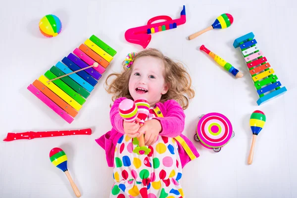 Kleines Mädchen mit Musikinstrumenten — Stockfoto