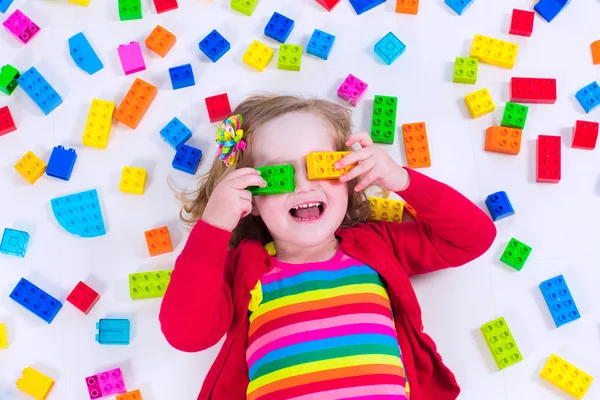 Kleines Mädchen spielt mit bunten Blöcken — Stockfoto