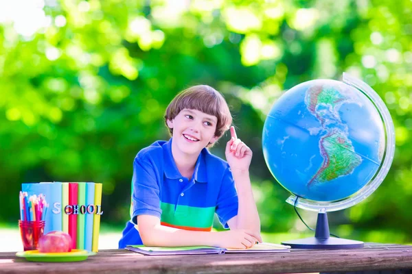 Ragazzo della scuola che fa i compiti nel cortile della scuola — Foto Stock