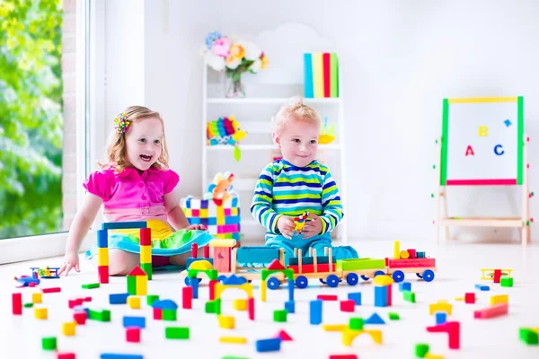 Crianças brincando na creche com brinquedos de madeira — Fotografia de Stock