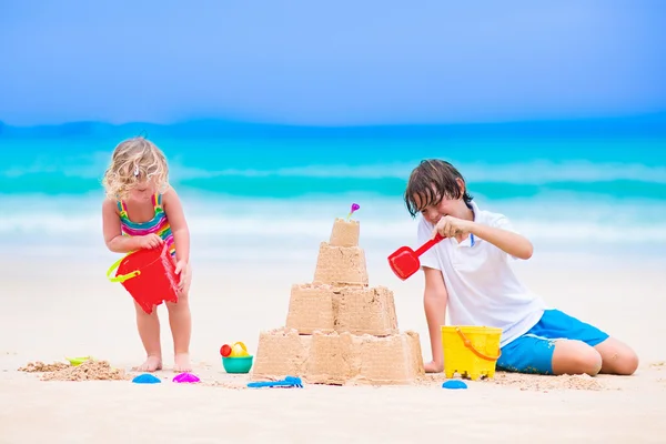 建筑在沙滩上的沙子城堡的孩子 — 图库照片