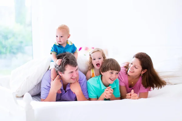 Familia con tres niños en el dormitorio — Foto de Stock