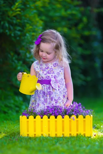 Kis lány dolgozik a kertben, virágok öntözése — Stock Fotó