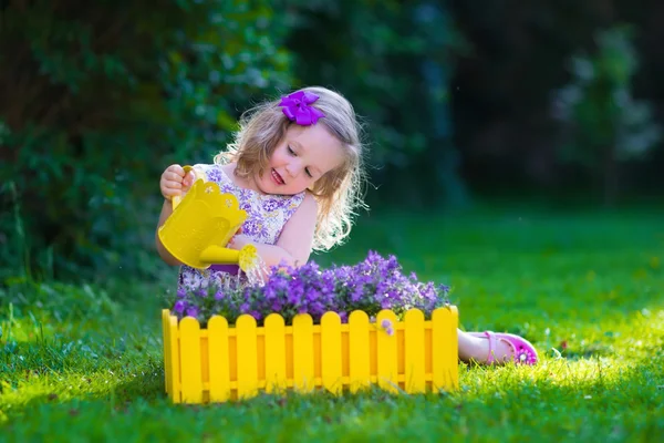 Menina trabalhando no jardim regando flores — Fotografia de Stock