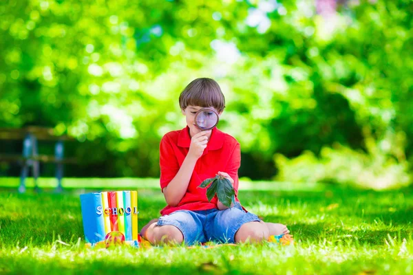 Kind in school tuin met Vergrootglas — Stockfoto