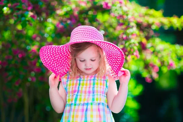 Menina em um chapéu no jardim de verão florescendo — Fotografia de Stock