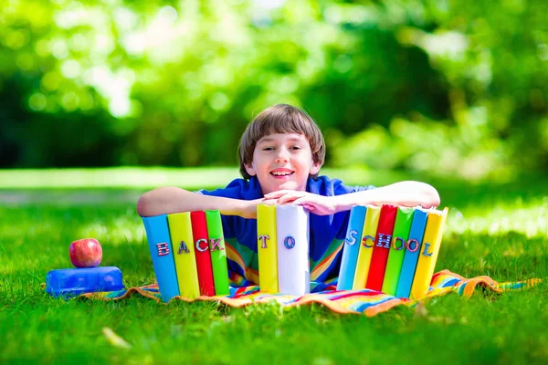 Estudante menino relaxante no quintal da escola leitura livros — Fotografia de Stock