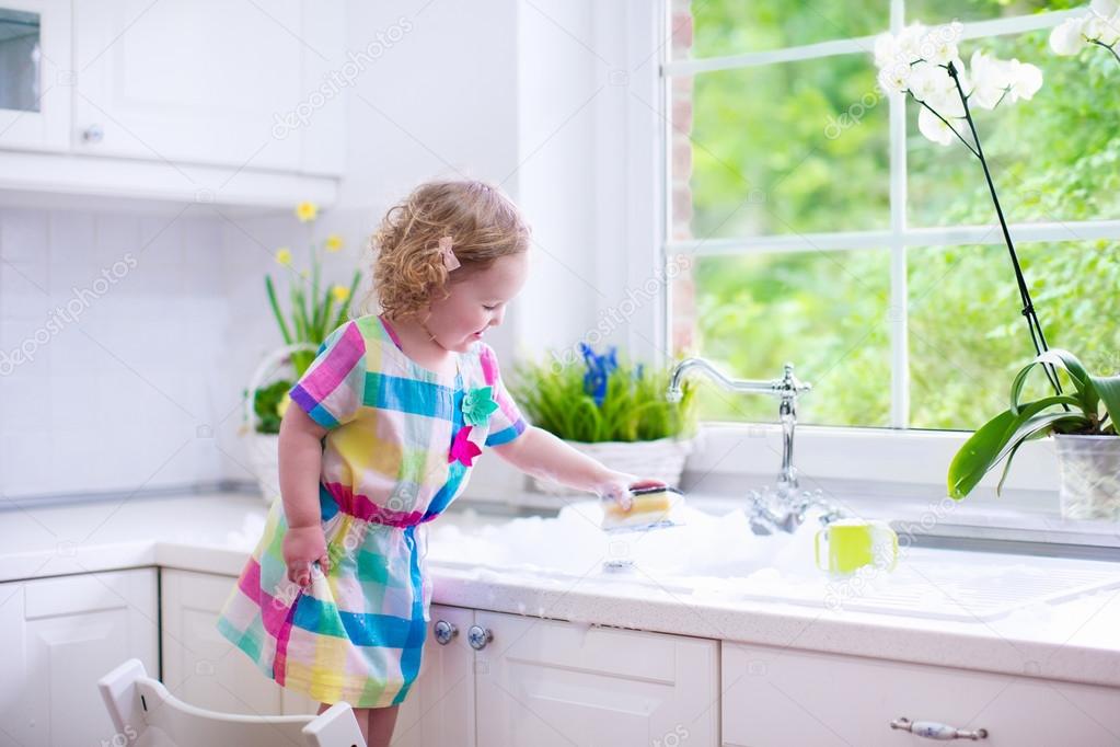 Little girl washing dishes