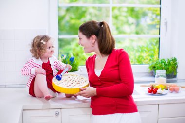 genç anne ve kızı birlikte bir pasta pişirme