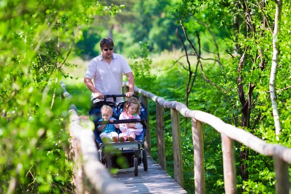 Junger Vater mit Doppelwagen im Park — Stockfoto