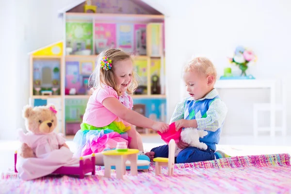 Crianças brincando com animais de pelúcia e casa de boneca — Fotografia de Stock